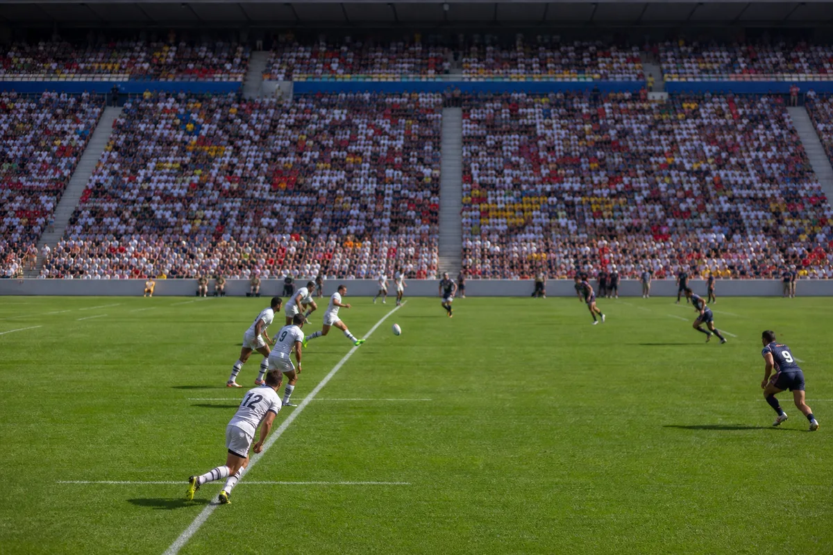 Stade olympique de rugby à sept au coup d’envoi, tribunes colorées et pelouse fraîchement tracée
