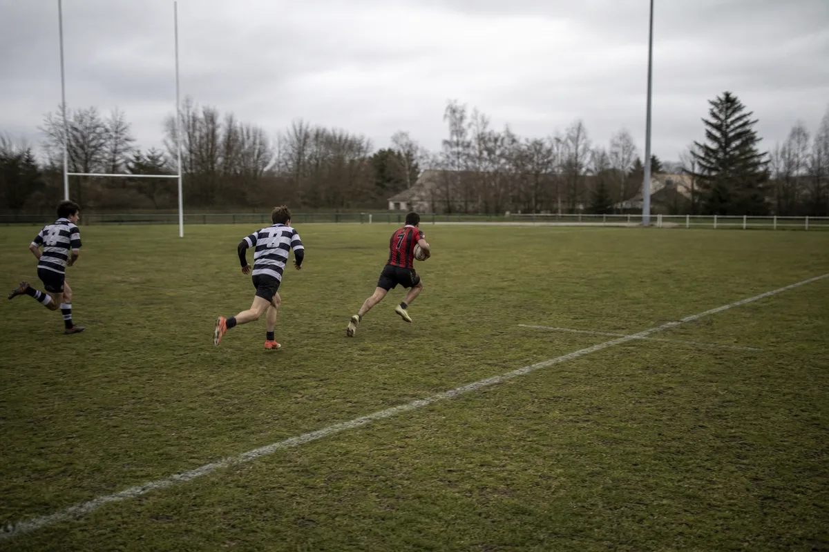 Match de rugby à sept en cours, un joueur lancé dans un large espace avec peu de défenseurs autour