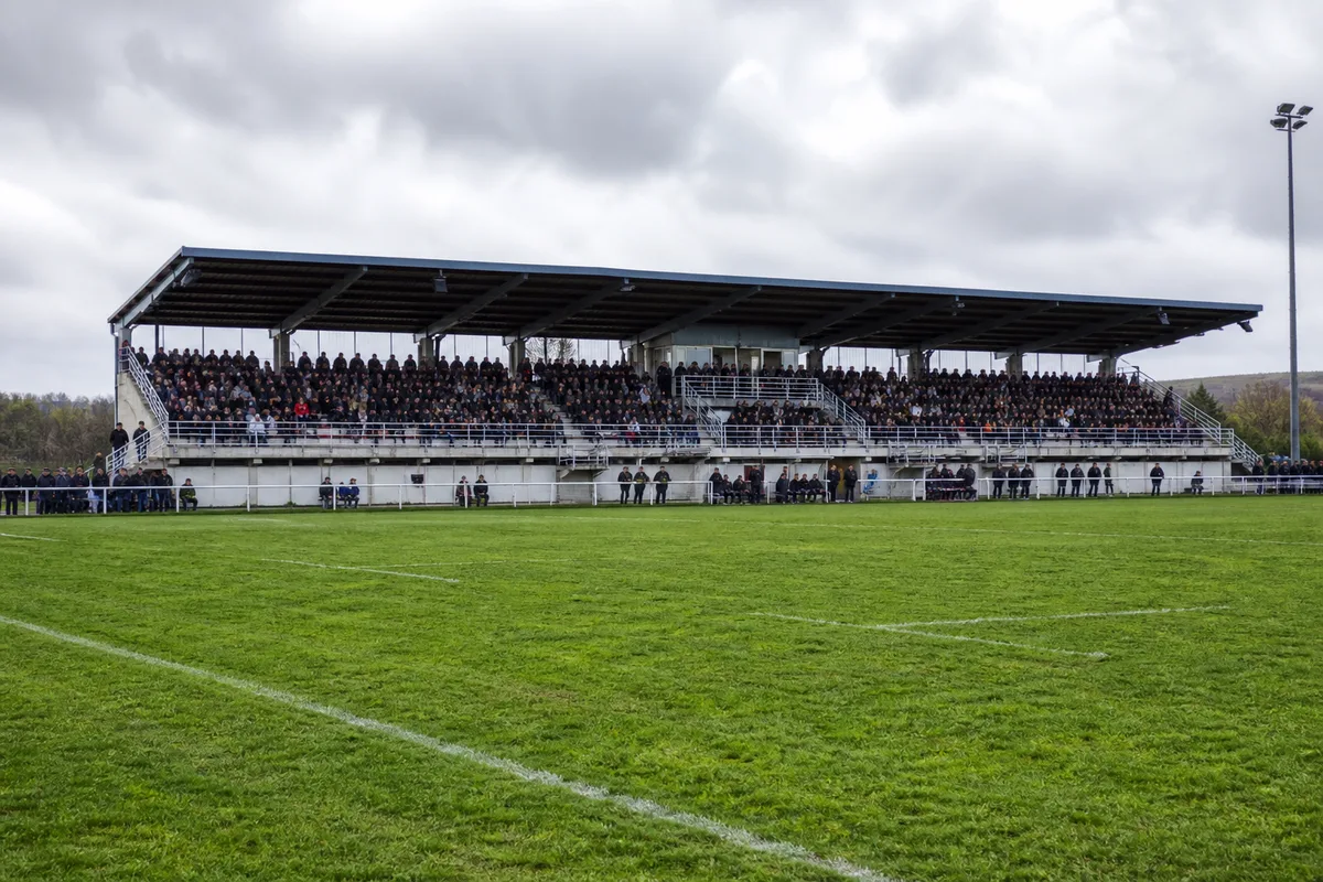 Tribune de stade de rugby remplie de supporters pendant un match de championnat
